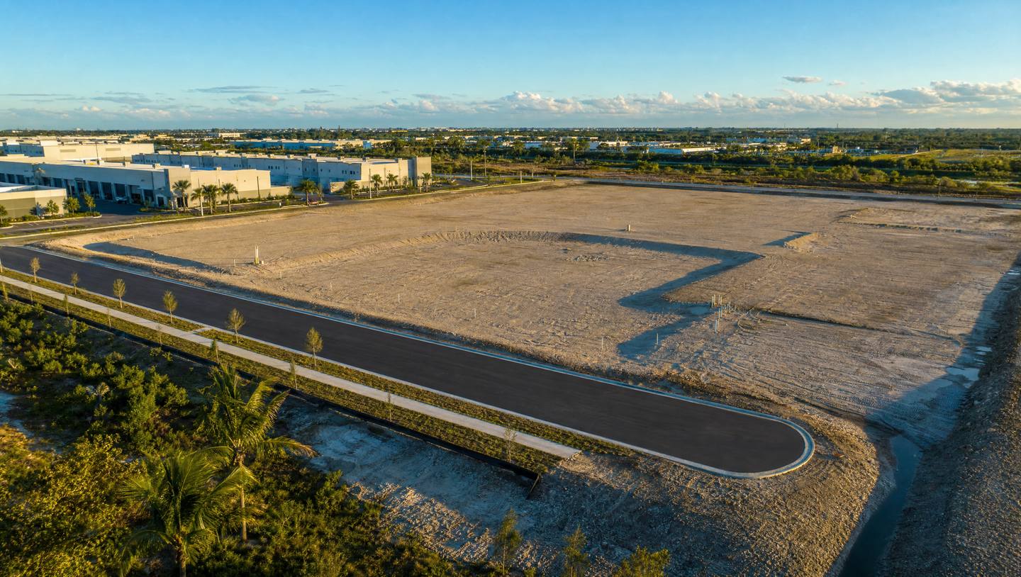 A graded, shovel-ready industrial parcel with a new access road beside completed flex buildings